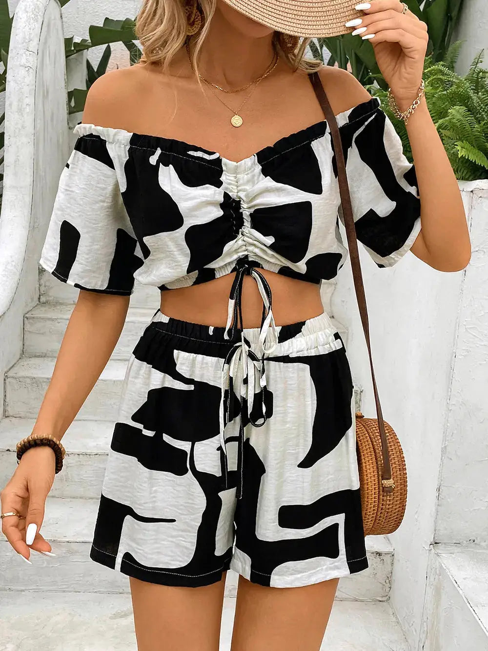 Perfee Drawstring Off-Shoulder Top and Shorts Set in black and white abstract print, featuring ruched front and elastic waist shorts.