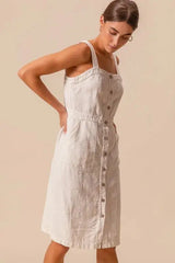 Side view of SO ME pinafore dress with button down front and relaxed fit, made from 100% cotton.