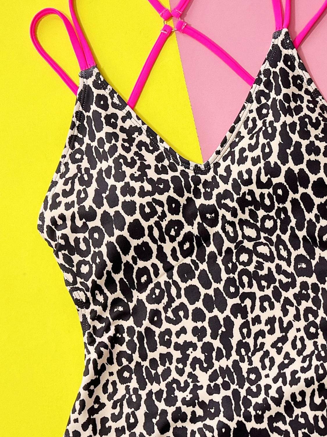 Close-up of classic Leopard Plunge Swimwear showing detailed leopard print and vibrant pink double straps.