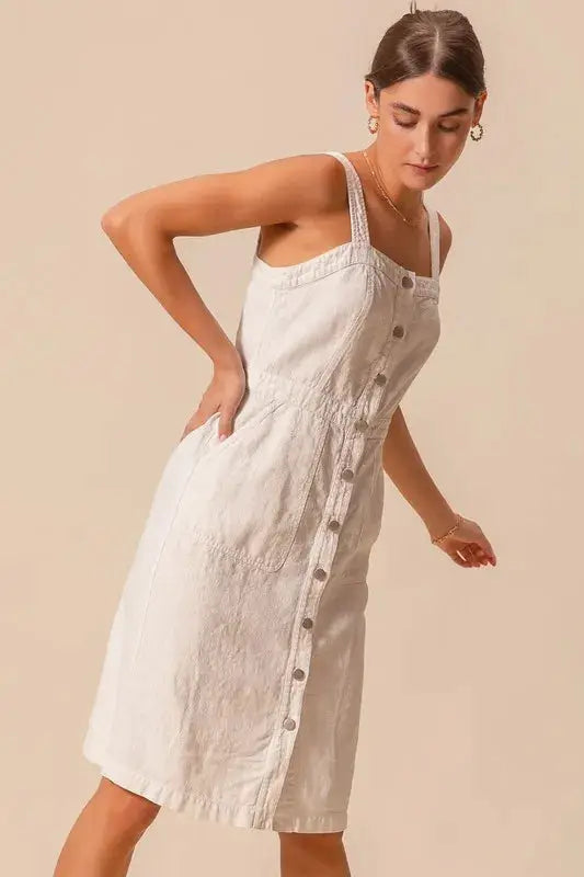 SO ME button down pinafore dress in off-white, featuring front pockets and a fitted waist for a flattering silhouette.