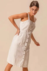 SO ME button down pinafore dress in off-white, featuring front pockets and a fitted waist for a flattering silhouette.