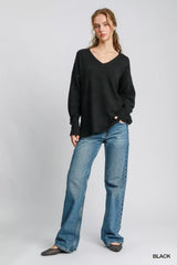 Woman wearing black Umgee Wool Blended Pullover Sweater with jeans, showcasing the oversized V-neck design, perfect for layering.