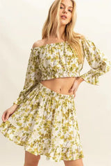 HYFVE Floral Off-Shoulder Flounce Sleeve Top and Skirt Set featuring a green floral print, cropped top, and ruffled mini skirt. Ideal for summer outings.