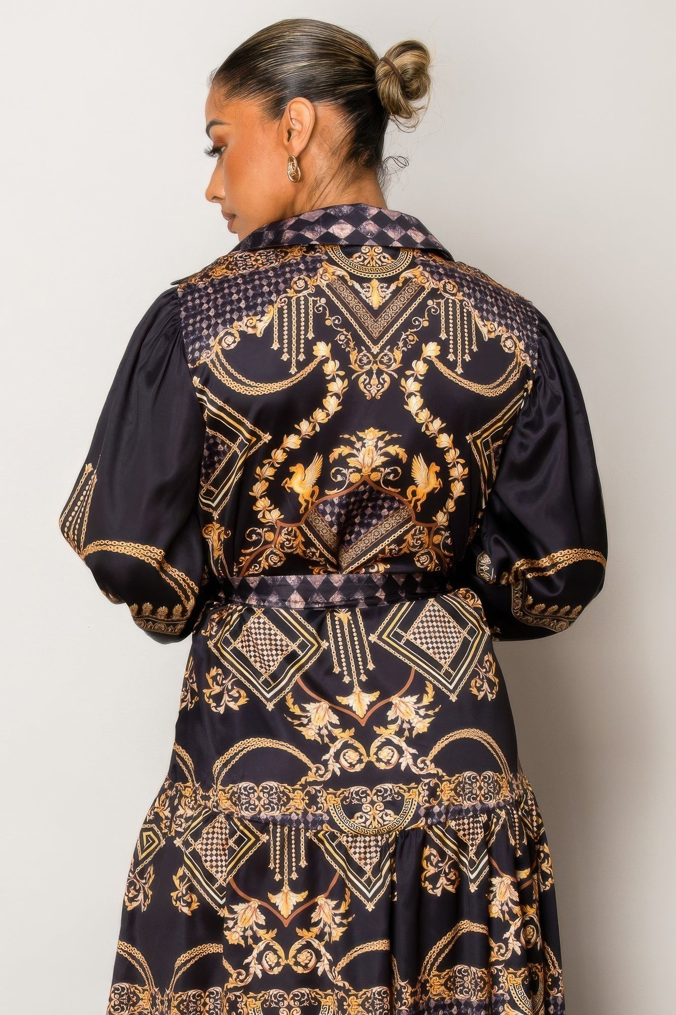 Woman wearing Resort Wear Maxi Dress with gold baroque patterns on a deep backdrop, perfect for elegant vacation occasions.