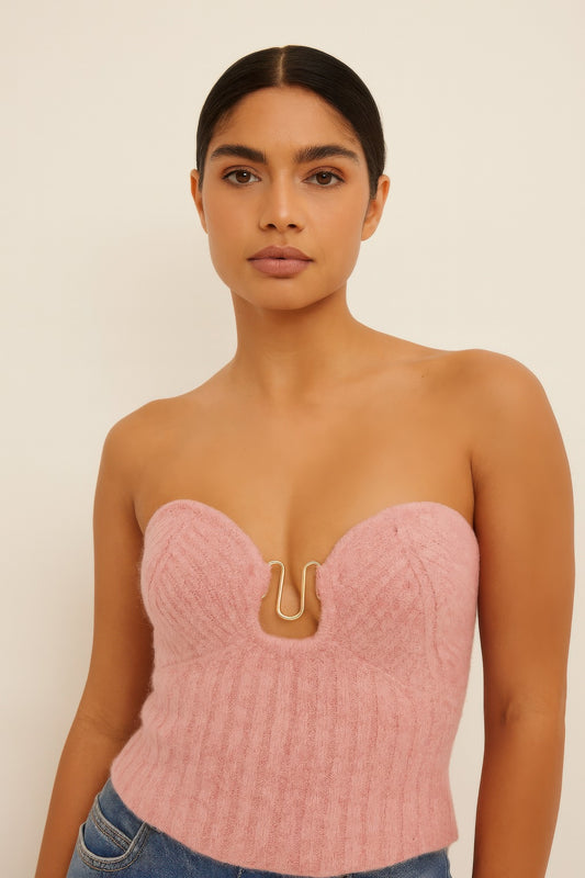 Model wearing pink knit tube top, chic and stylish design, strapless with front detailing, perfect for layering or solo wear.