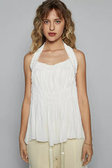 Model wearing POL Backless Halter Sleeveless Top with Smocking Shirring Detail in white, showing chic style and elegance.