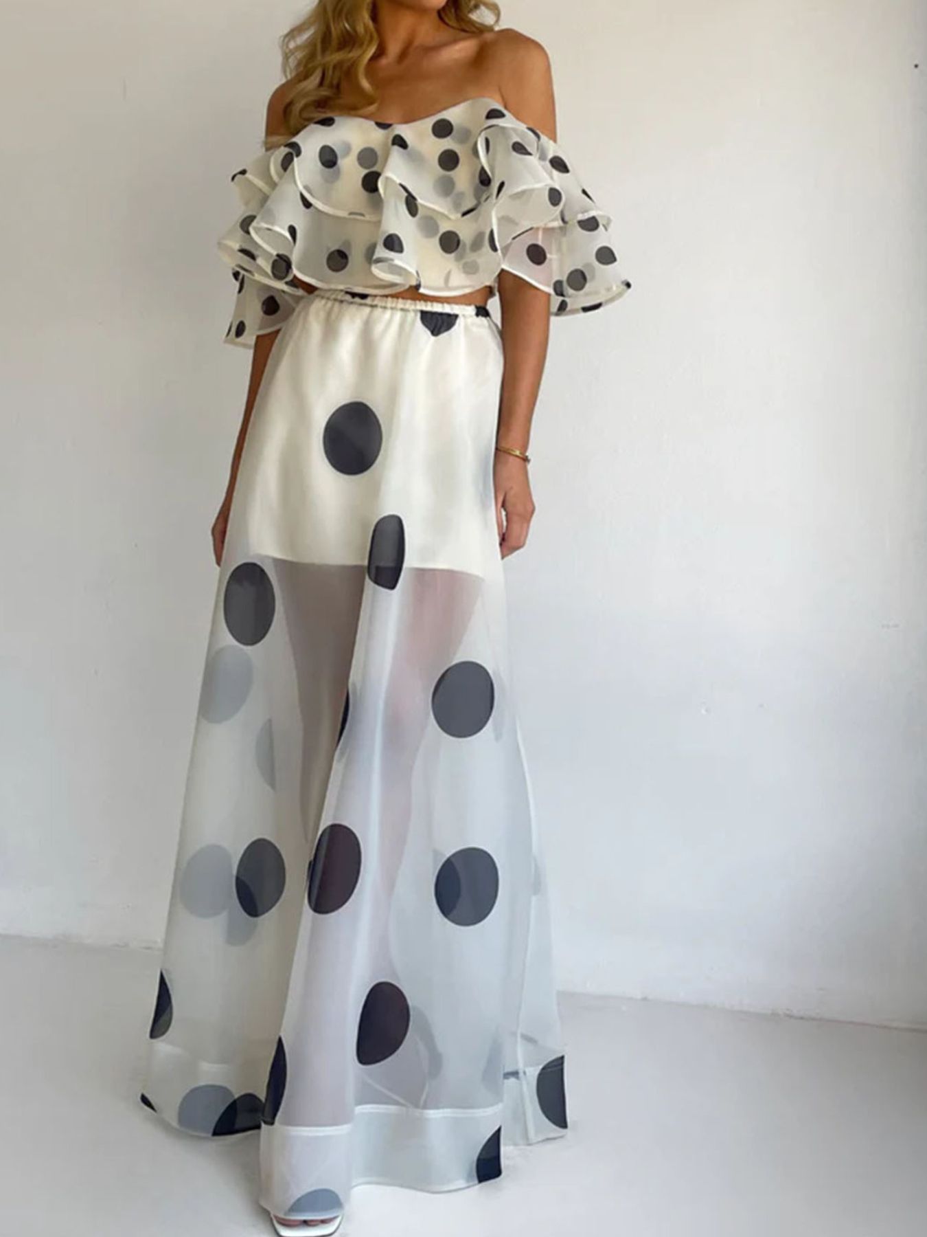 Woman wearing Polka Dot Ruffle Crop Top and Maxi Skirt Set, featuring an off-shoulder ruffle top and flowing high-waisted skirt for summer.