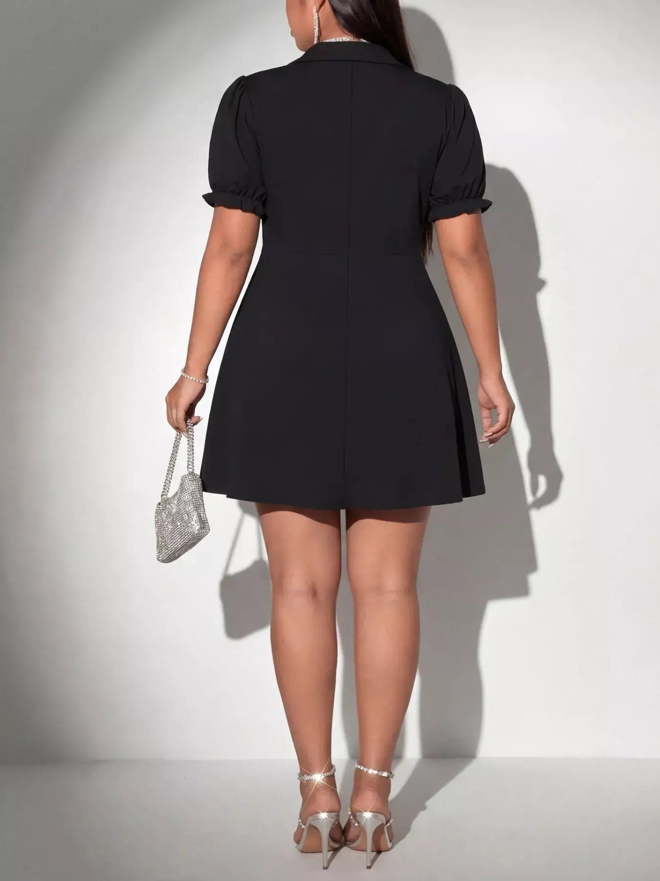 Back view of a Black Plus Size Short Sleeve Mini Dress with puff sleeves and a flared skirt.