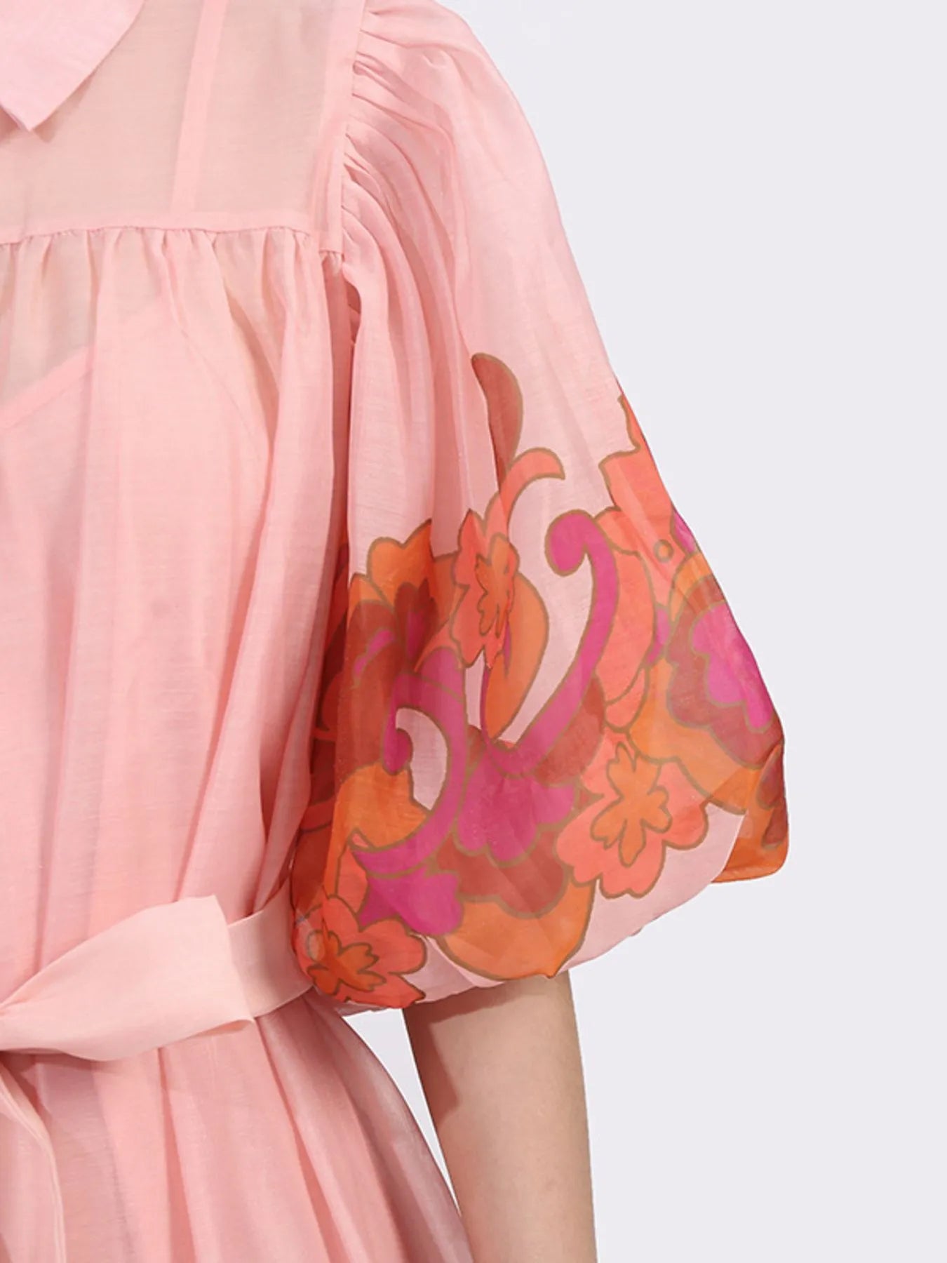 Detail of Button Front Puff Sleeve Dress in blush with floral accents, featuring a puff sleeve and belted waist for a romantic look.