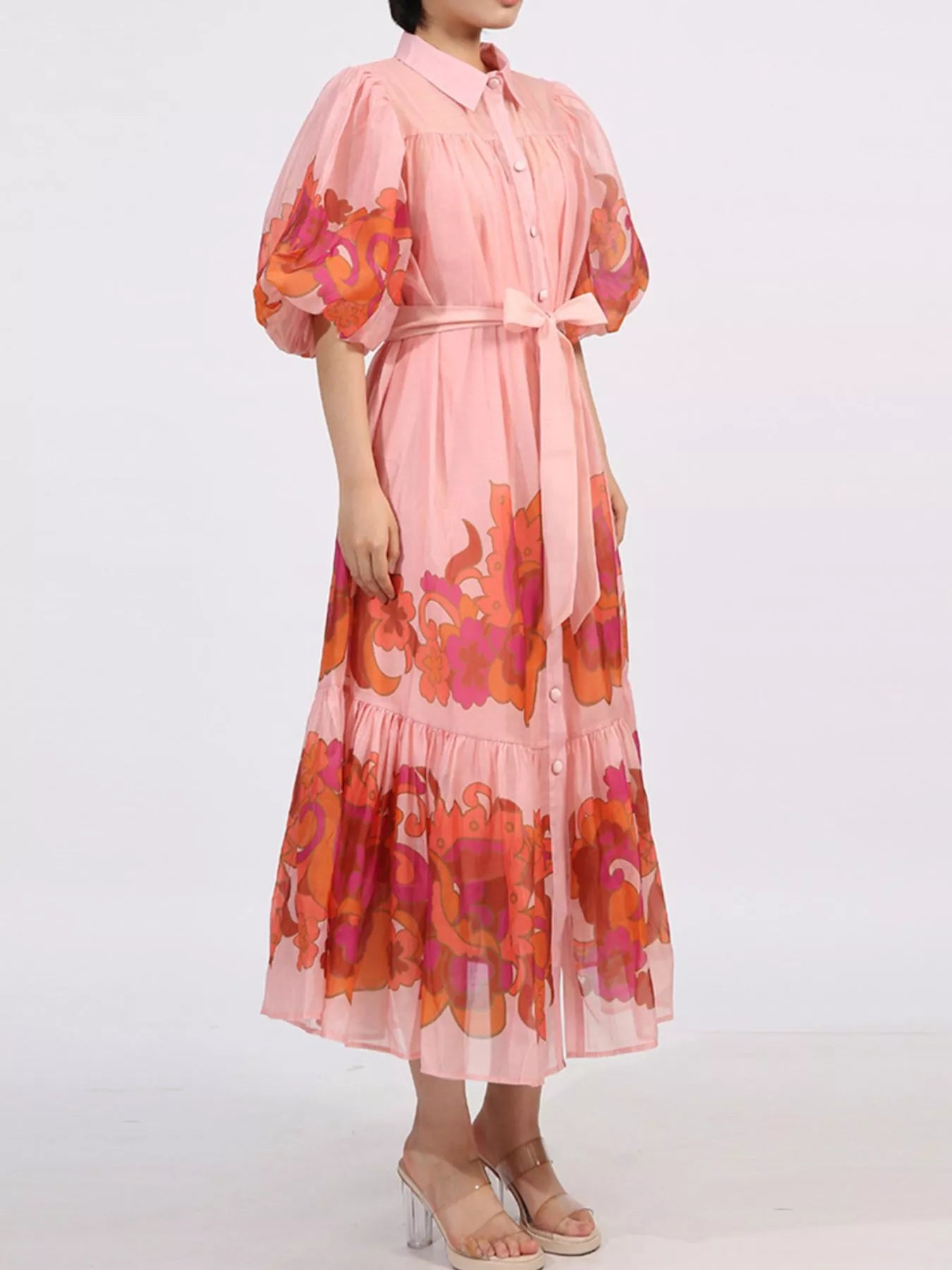 Blush button front puff sleeve dress with floral accents, belted waist, and tiered ruffle hem, perfect for elegant occasions.