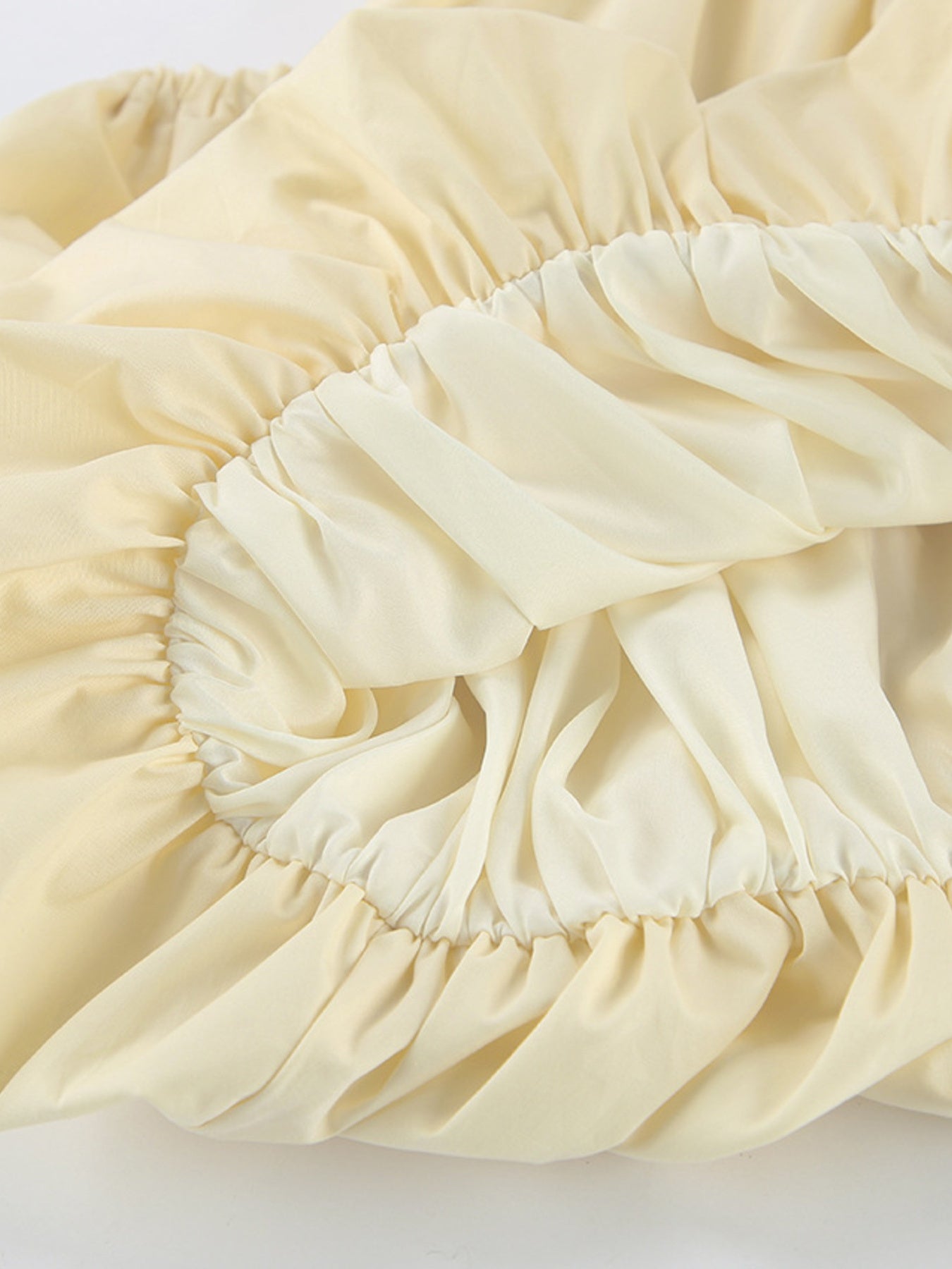 Button Front Bubble Hem Dress detail showcasing the soft, gathered bubble hem design in light yellow fabric.