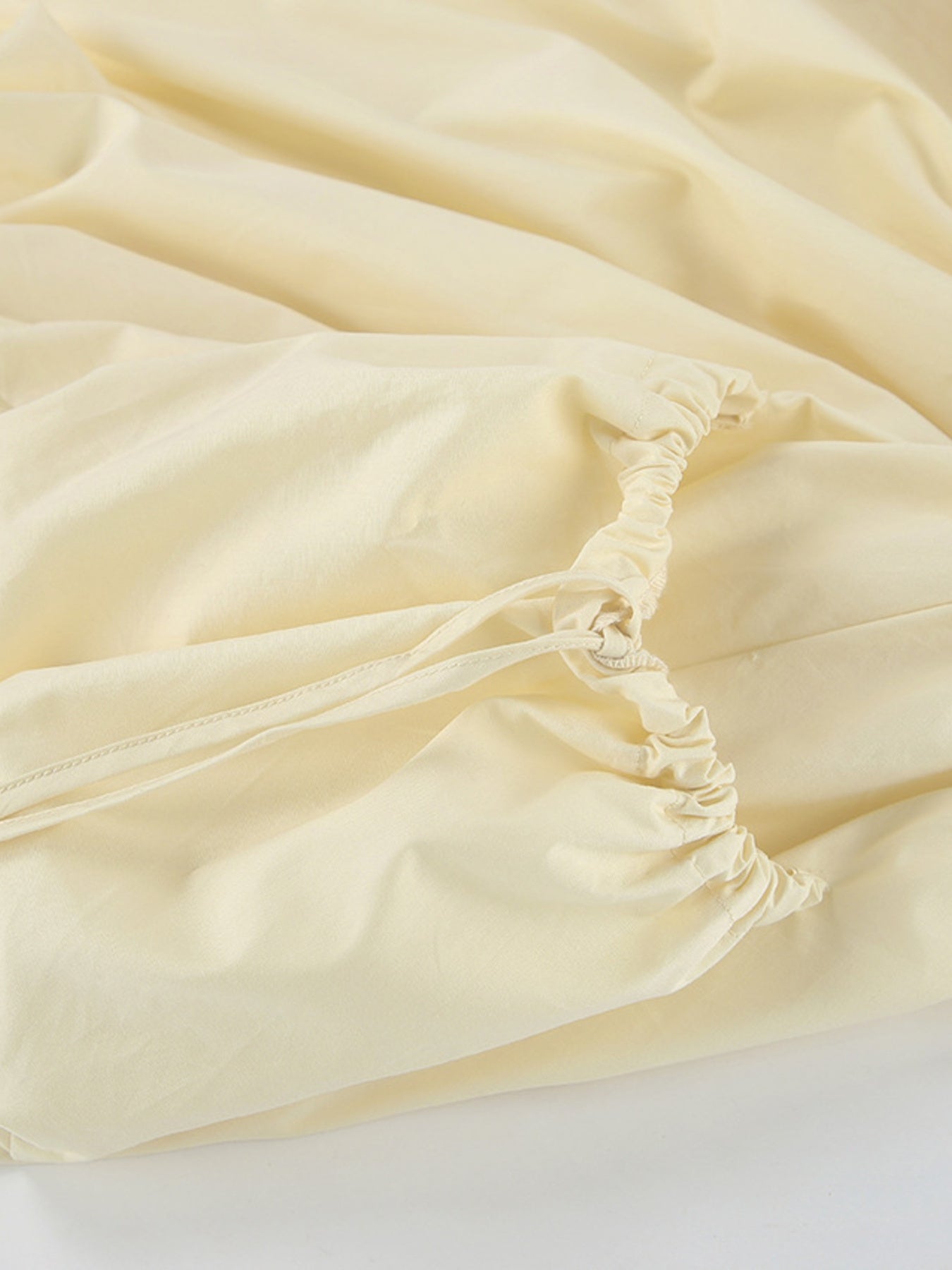 Button Front Bubble Hem Dress detail showing elastic waist and lightweight fabric in soft yellow shade.