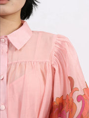Close-up of Button Front Puff Sleeve Dress in blush with floral accents, showcasing detailed puff sleeves and button-down design.