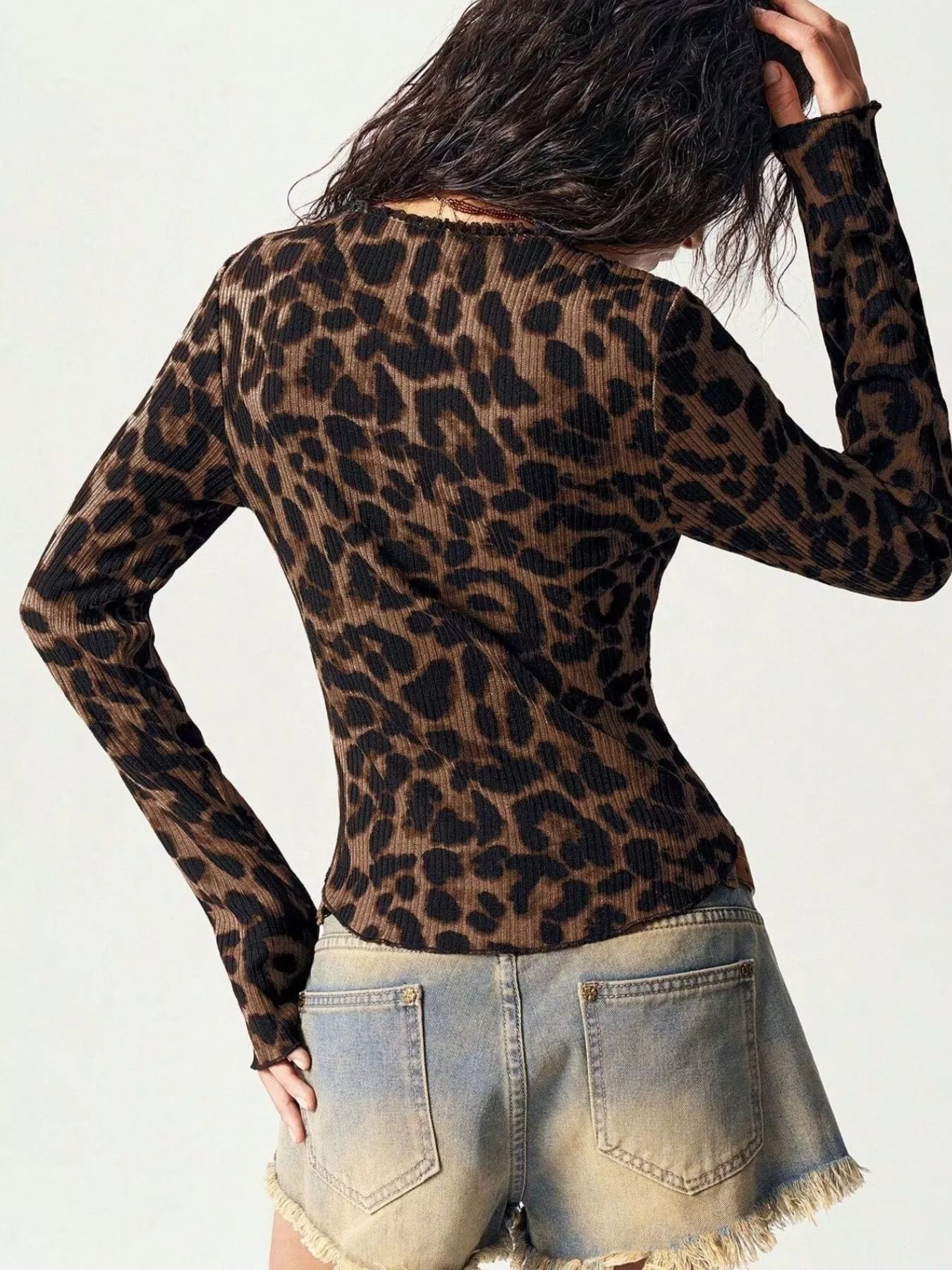 Back view of Leopard Print Button-Down Top with lace accents, paired with frayed denim shorts.
