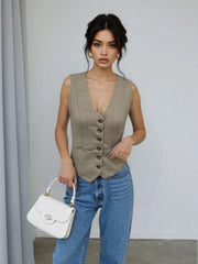 Woman wearing a Plaid Button Down Vest | Savvy with jeans, holding a white handbag.