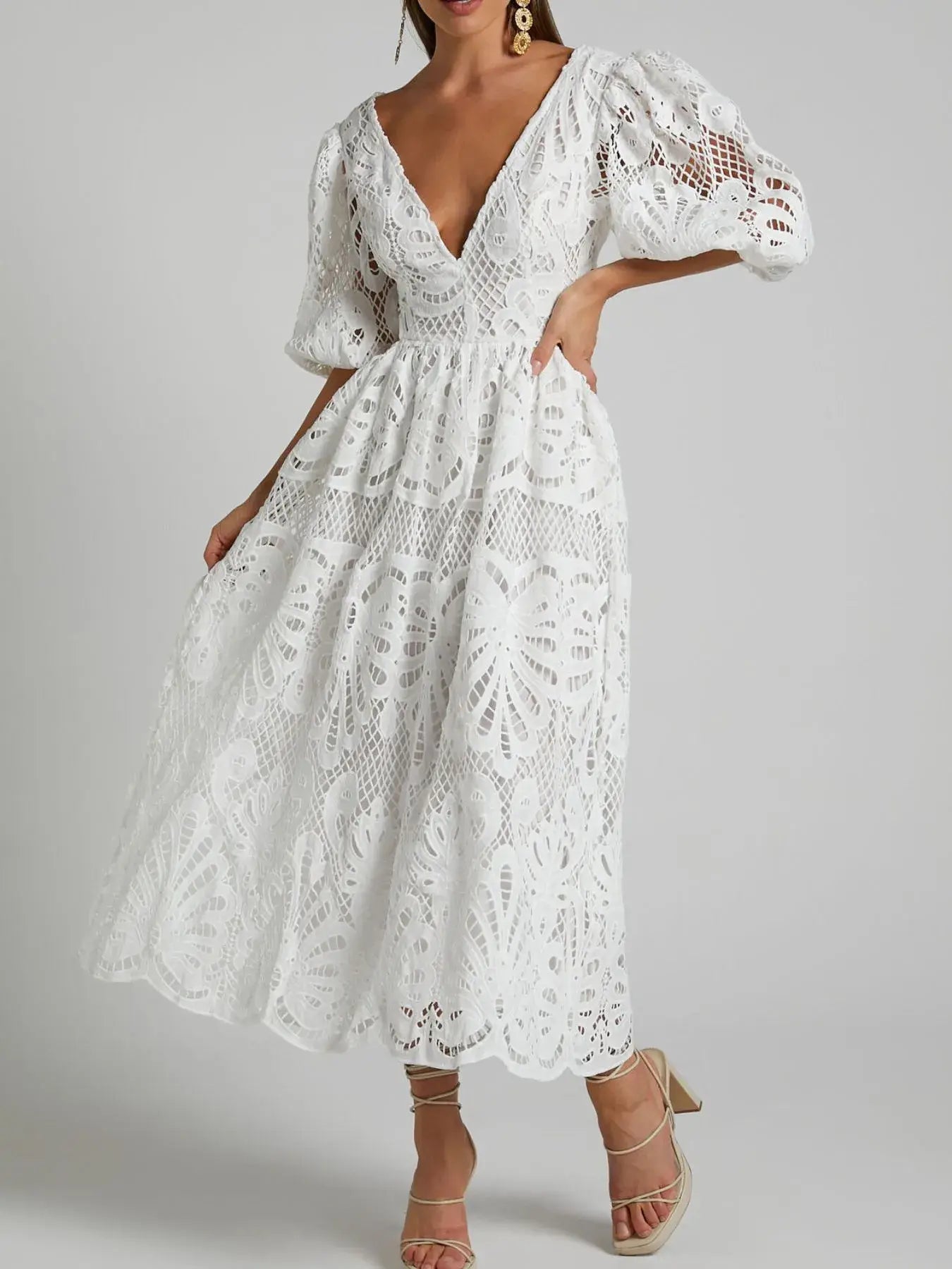 Elegant white lace dress with cutout back, crochet details, and V-neckline, perfect for special occasions and evening events.