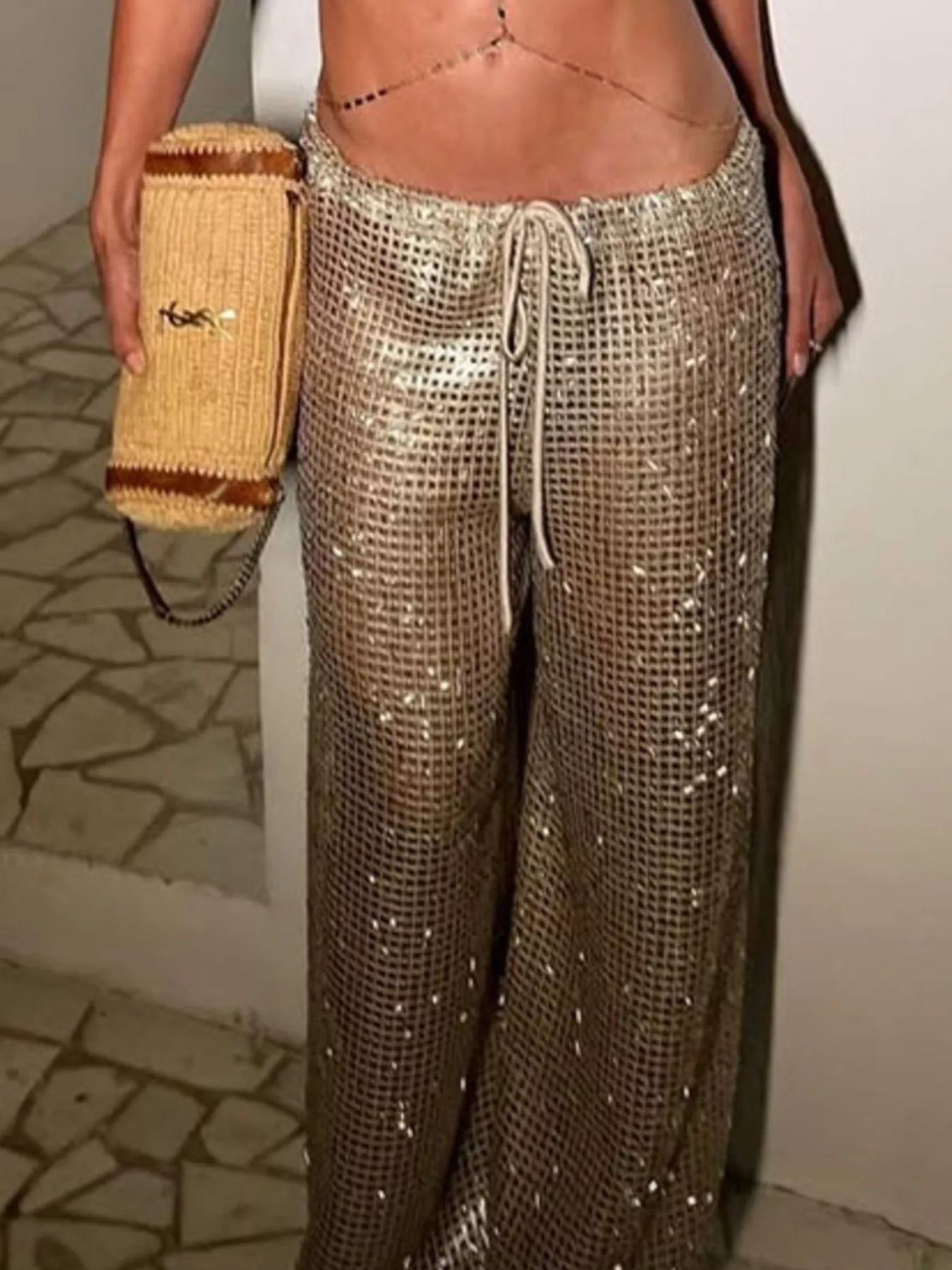 Drawstring wide leg pants in a shimmering design, paired with a stylish handbag, perfect for summer outings.