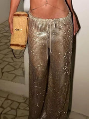 Drawstring wide leg pants in a shimmering design, paired with a stylish handbag, perfect for summer outings.