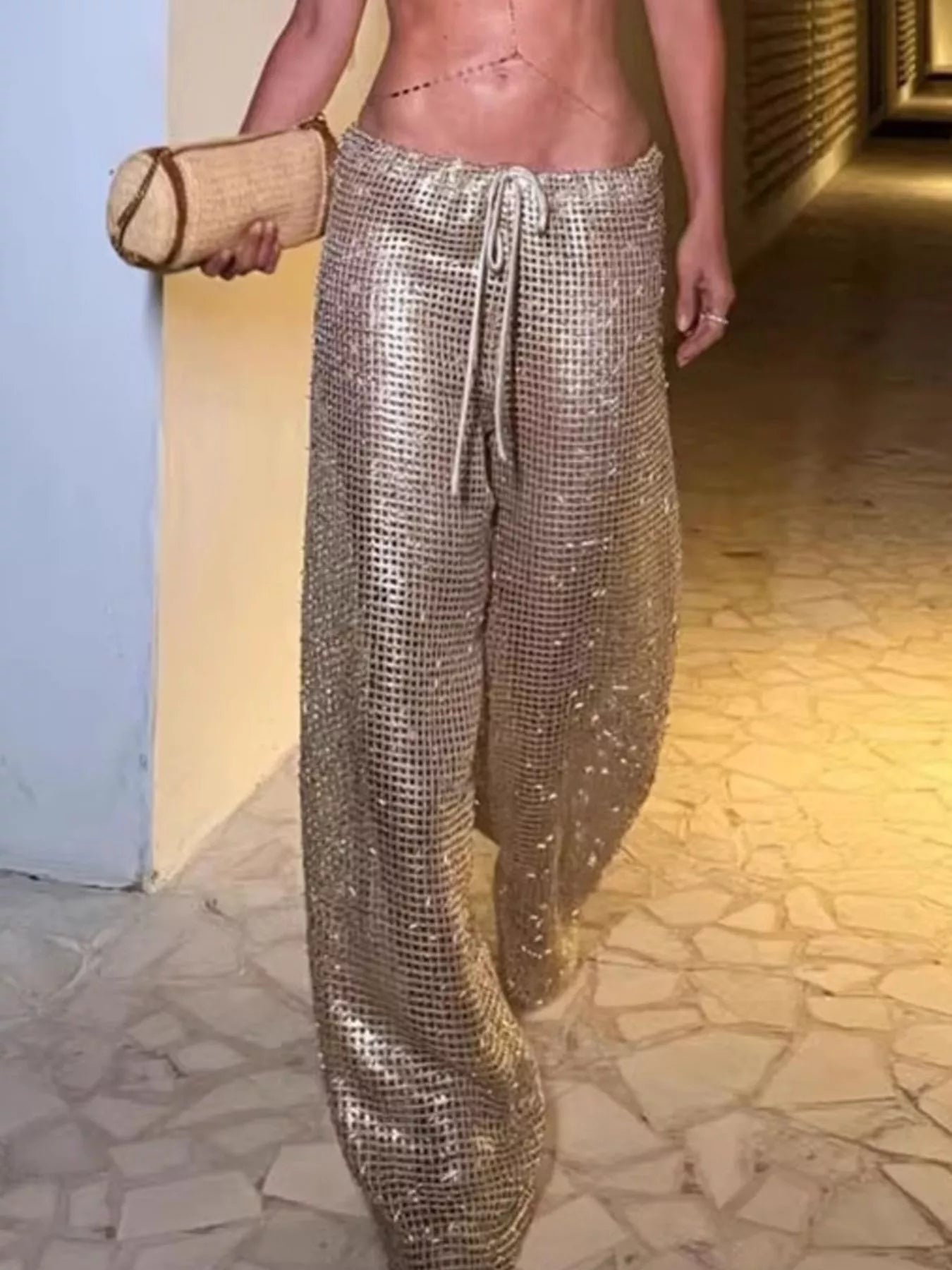 Woman wearing drawstring wide leg pants in shiny metallic fabric, showcasing a stylish summer look.