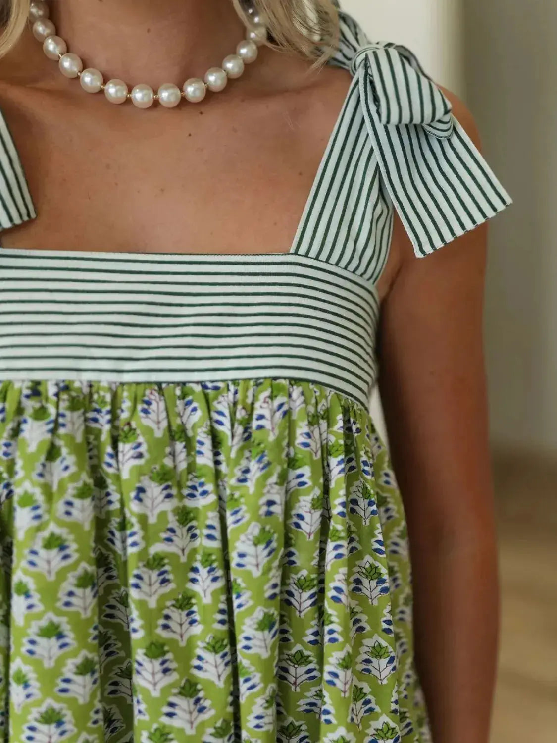 Close-up of green Printed Square Neck Tie Shoulder Mini Dress showing striped bodice and floral fabric detail.