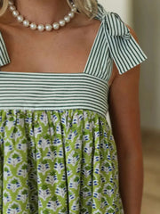 Close-up of green Printed Square Neck Tie Shoulder Mini Dress showing striped bodice and floral fabric detail.