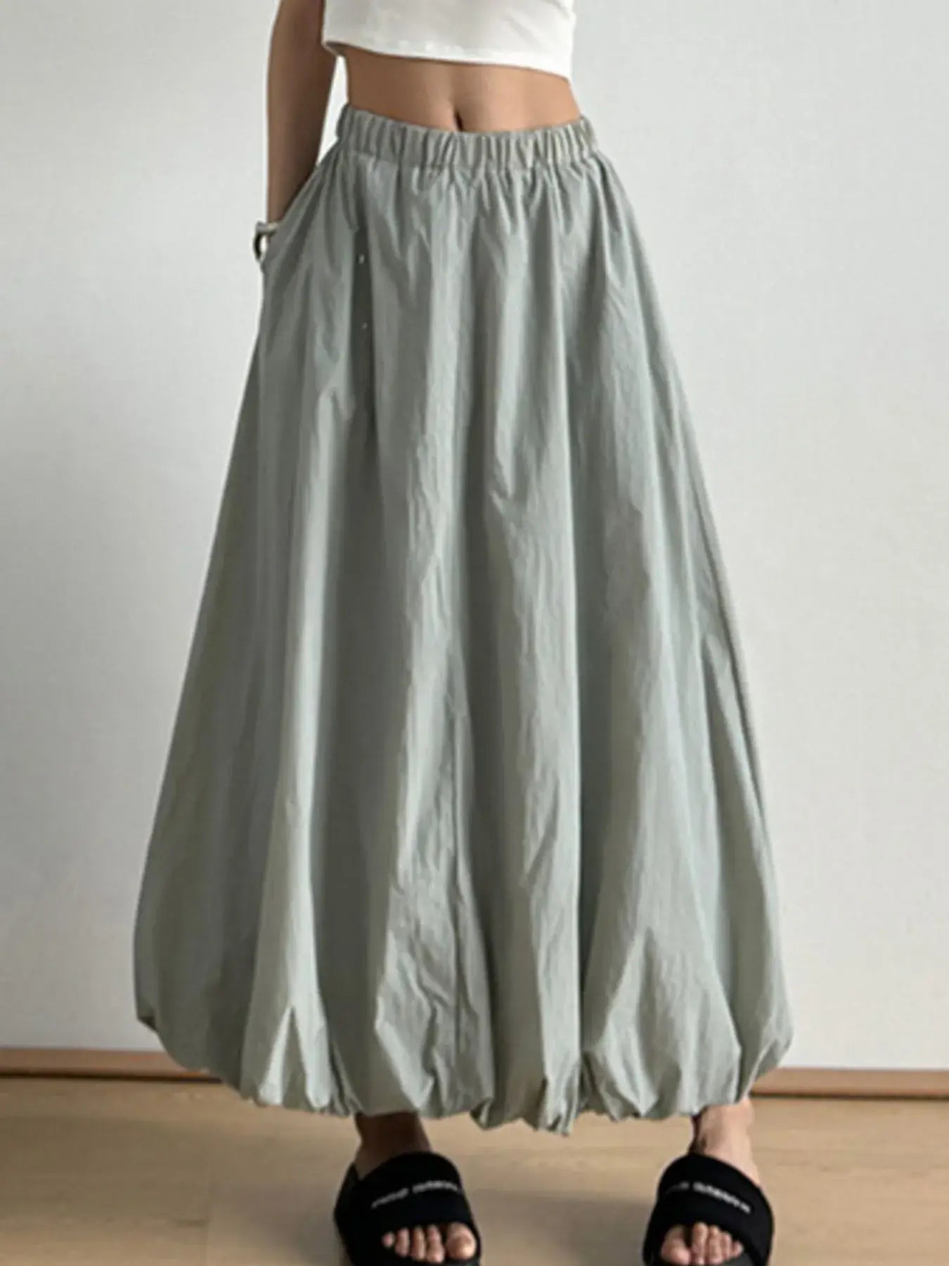 Elastic waist bubble hem maxi skirt with paperbag waist and drawstring, featuring a clean silhouette and functional pockets.