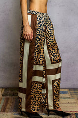 Woman wearing POL Leopard Printed Woven Wide Leg Drawstring Pants, showcasing bold leopard print and comfortable wide leg design.