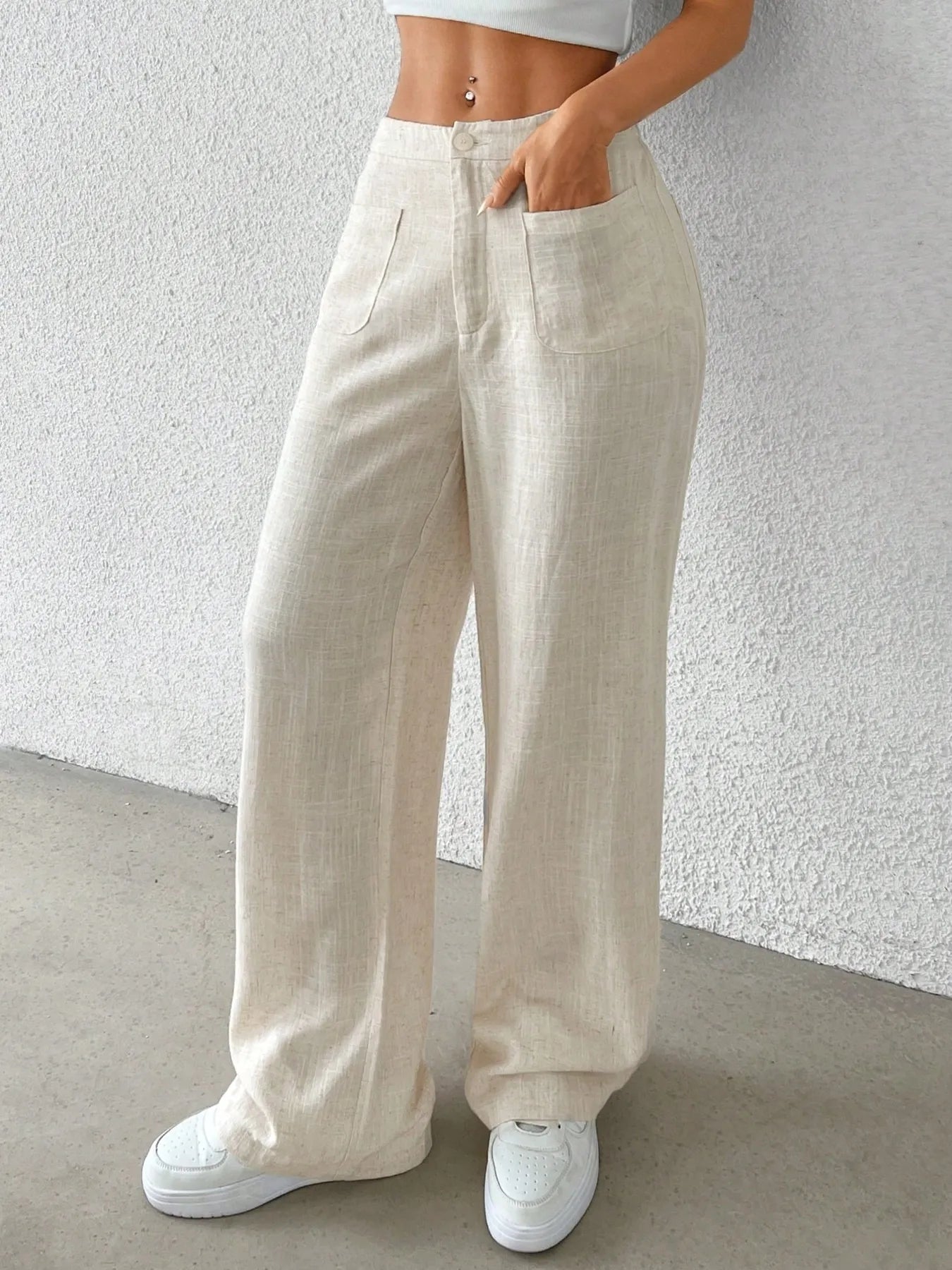 Fashionable Chic Wide-Leg Pants by GirlSavvi in beige color with pockets, styled with a crop top and sneakers.