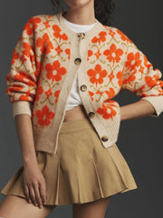 Model wearing flower button-up long sleeve cardigan with orange floral design, paired with a khaki skirt, showcasing its detailed craftsmanship.