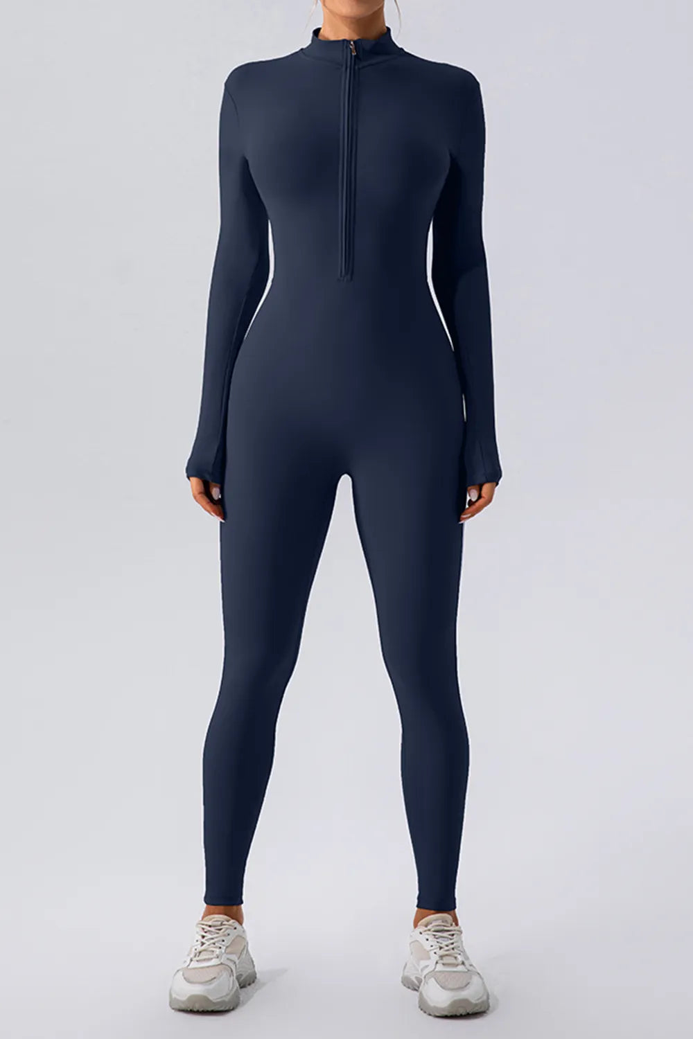 Model wearing Half Zip Mock Neck Active Jumpsuit in navy blue, showcasing its sleek design and sporty style.