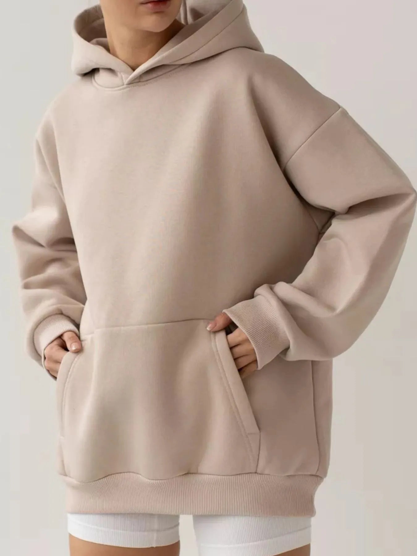 Taupe kangaroo pocket long sleeve hoodie with a hood, shown on a model, highlighting its cozy, stylish and functional design.