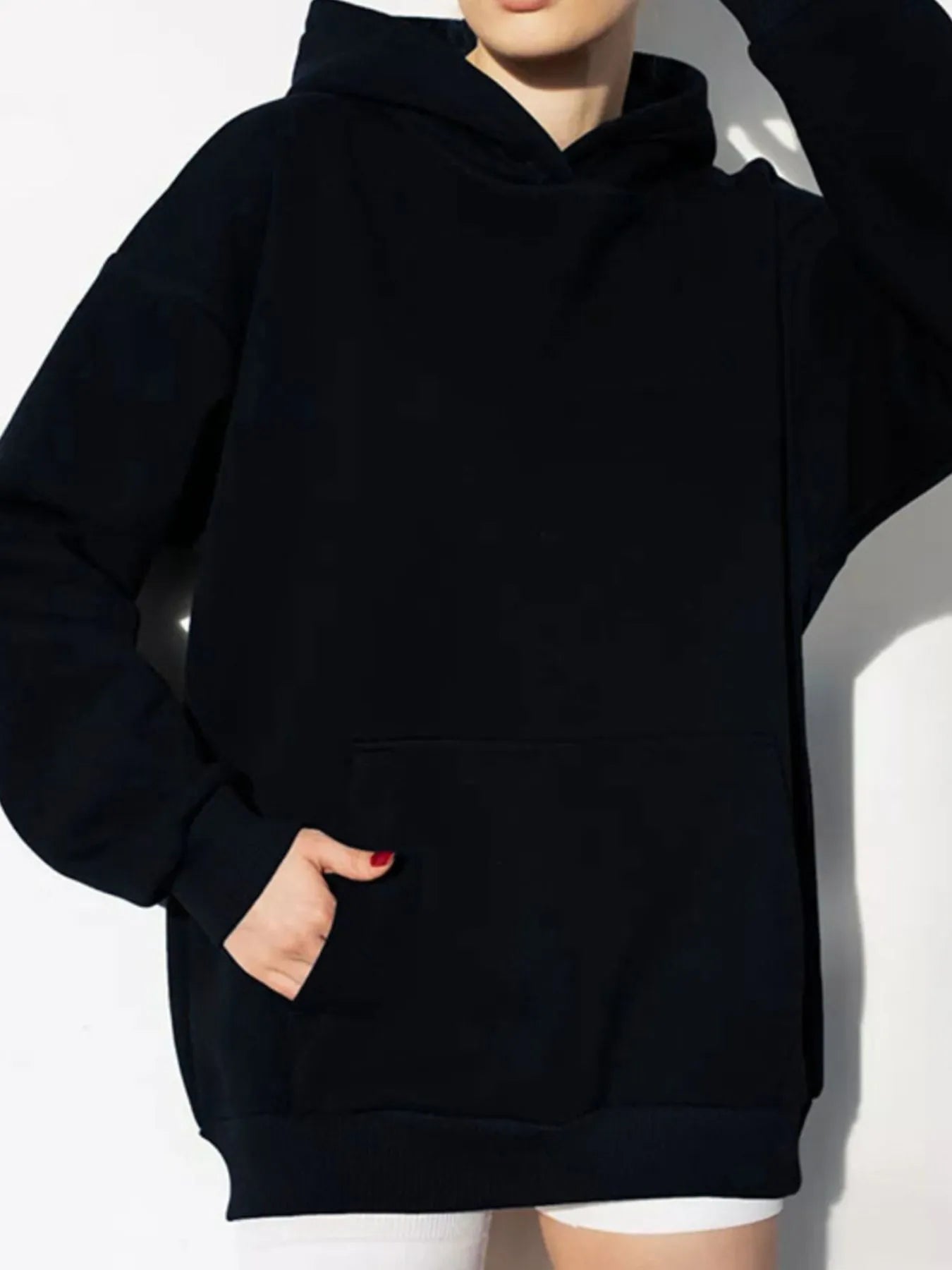Black kangaroo pocket long sleeve hoodie with a relaxed fit, featuring a cozy design and convenient front pocket for practical use.