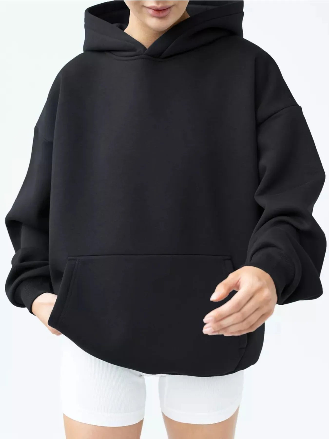 Black kangaroo pocket long sleeve hoodie, soft polyester-spandex blend, featuring a relaxed fit and practical pocket design.