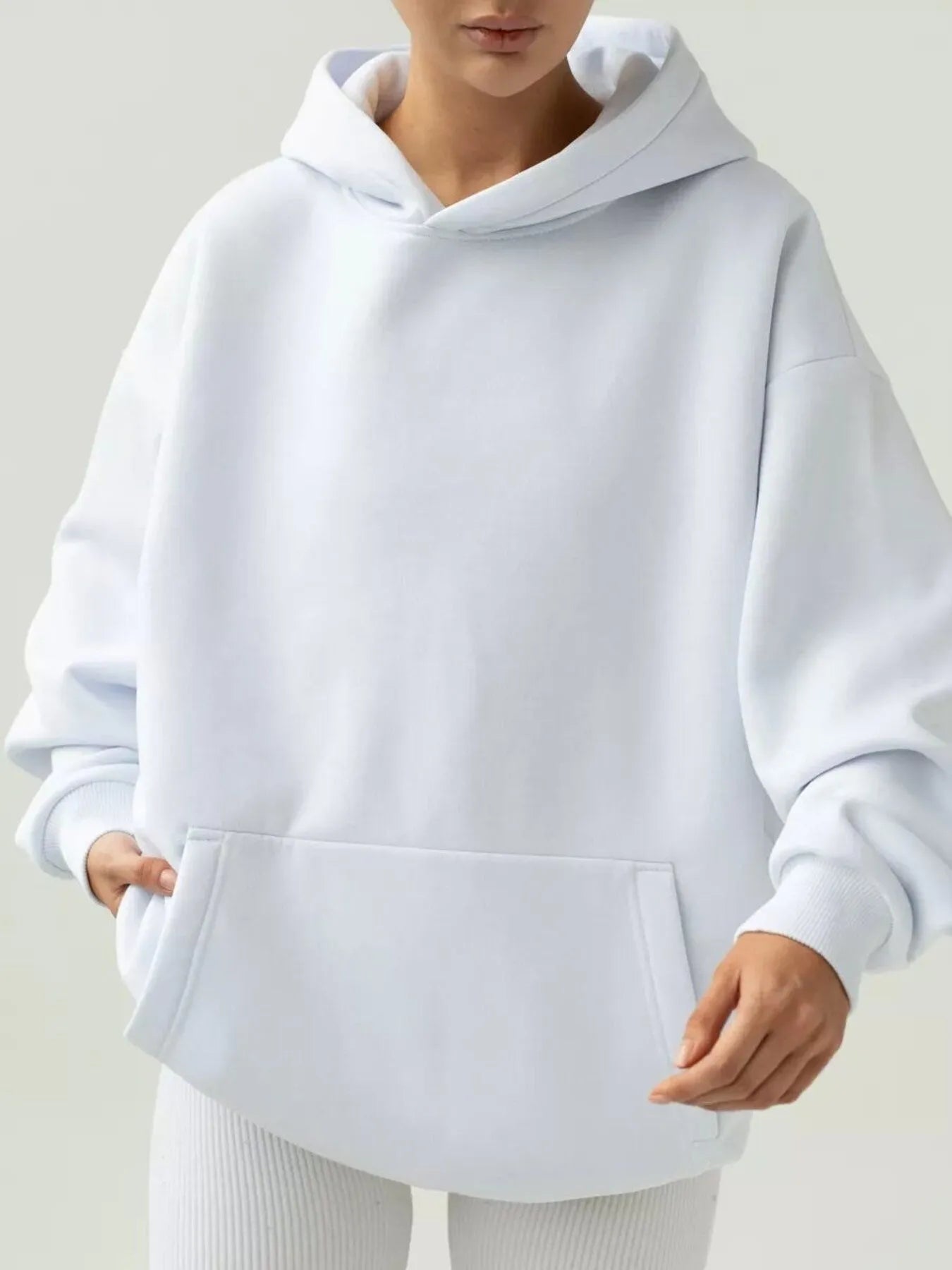 White kangaroo pocket long sleeve hoodie with soft fabric and sleek design, perfect for comfort and practicality.