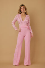 Lace Crochet Long Sleeve Jumpsuit in pink with a plunging V-neckline and flared pants on a model against a neutral background.