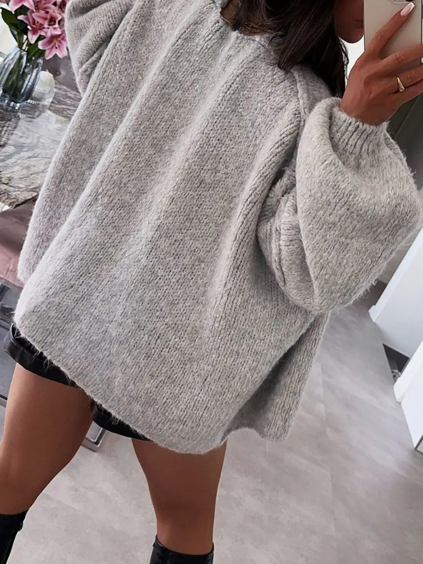 Woman wearing an oversized grey textured open front dropped shoulder cardigan with voluminous sleeves, perfect for chic layering.
