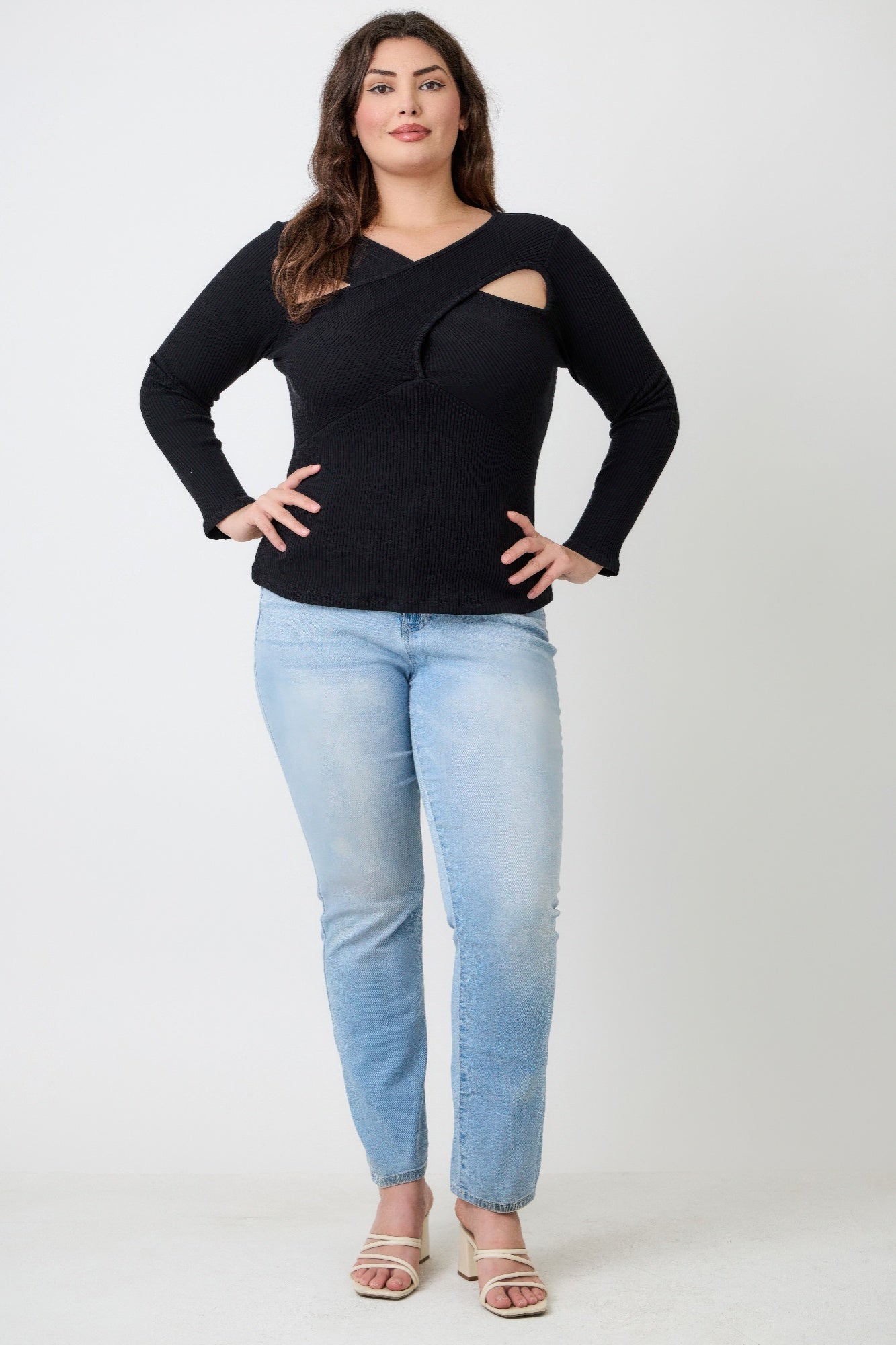 Plus Size Black Ribbed Cutout Long Sleeve Top worn with light blue jeans, showcasing a modern style and fitted silhouette.