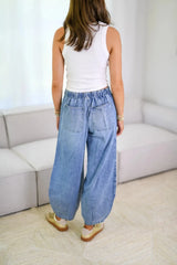 Model wearing Relaxed Drawstring Jeans with Pockets, showing back view and oversized pockets, styled with a tank top.