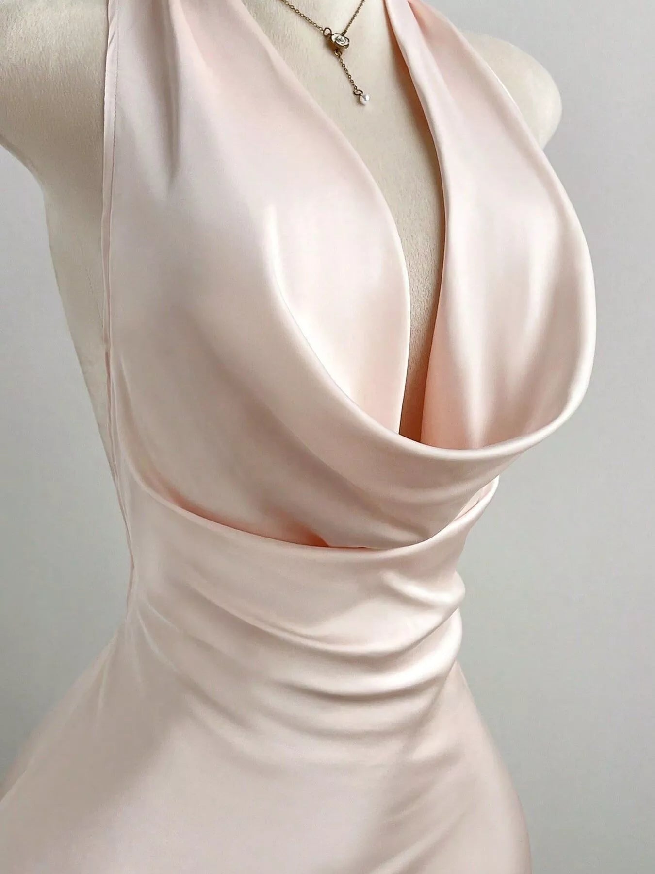 Satin Backless Halter Neck Dress featuring a deep neck and ruched detailing on a mannequin.