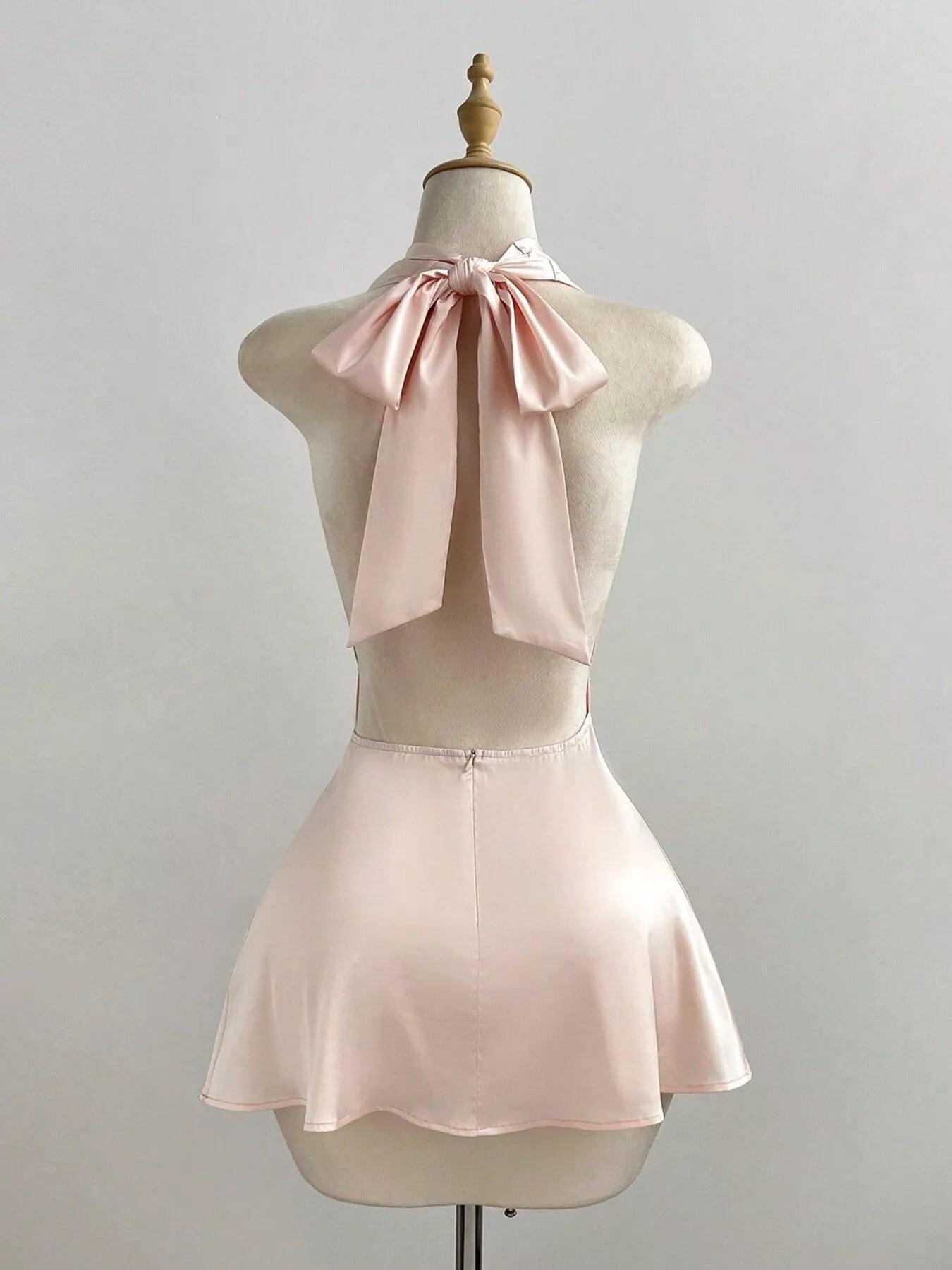 Satin Backless Halter Neck Dress showcasing a tied halter neck and ruched detailing in soft pink.