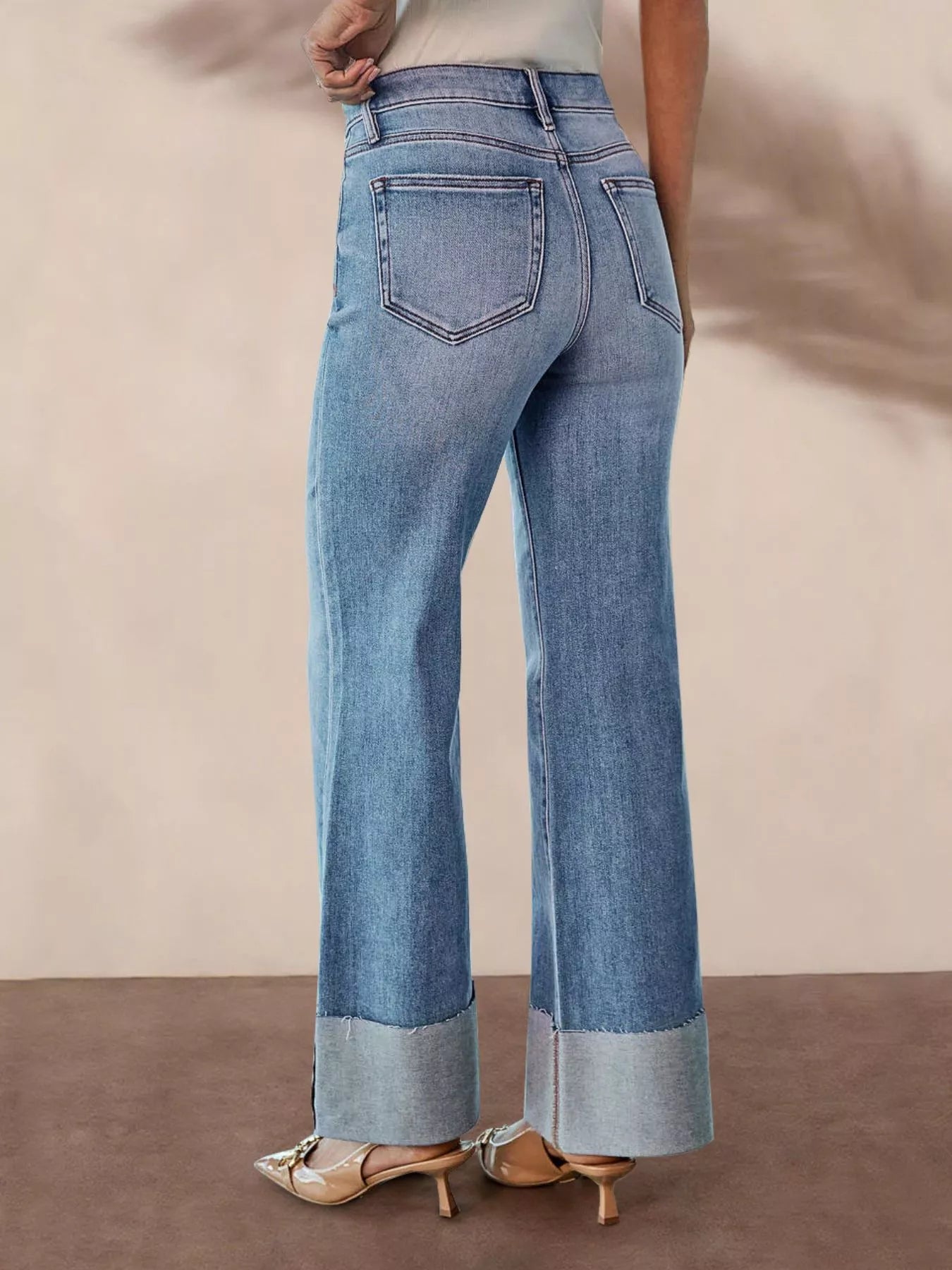 Distressed High-Waisted Flare Jeans showcasing the back view design and raw hem details.