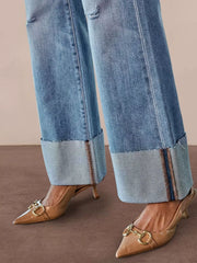 Distressed High-Waisted Flare Jeans showcasing raw hem and styled with nude high heels.