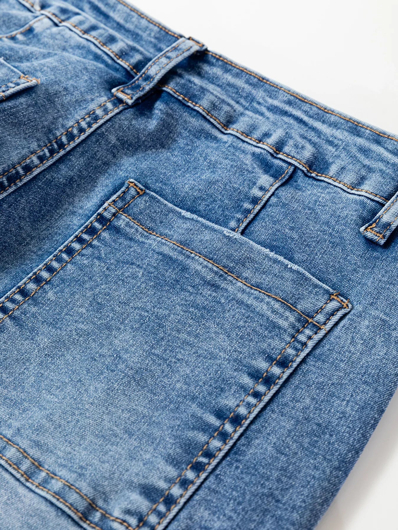 Close-up of seam detail loose fit cropped jeans with pocket, showcasing denim texture and stitching.
