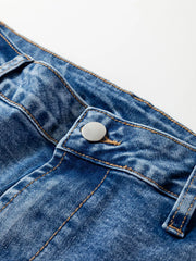 Close-up of seam detail loose fit cropped jeans highlighting button and stitching on denim fabric.