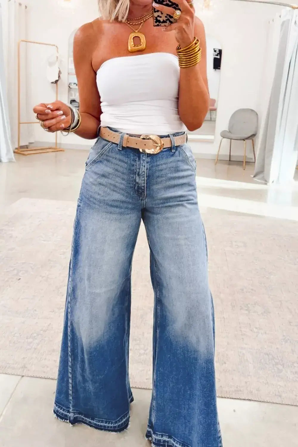 Woman wearing Side Seam Gathering Flare Leg Jeans with a strapless top and accessories in a stylish indoor setting.