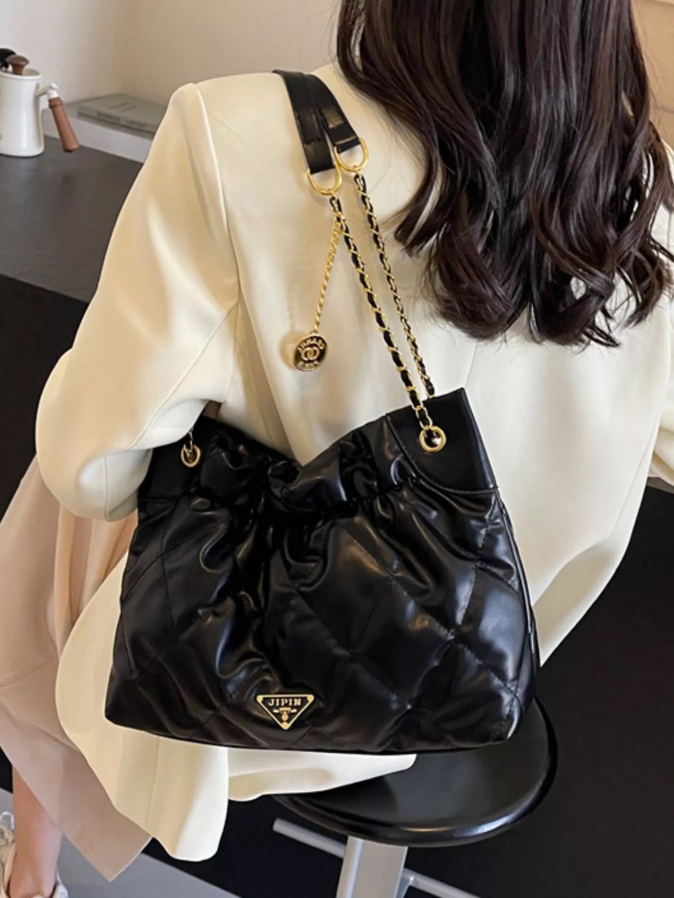 Summer Ruched Leather Shoulder Bag displayed on a model in a stylish outfit with a chic setting.