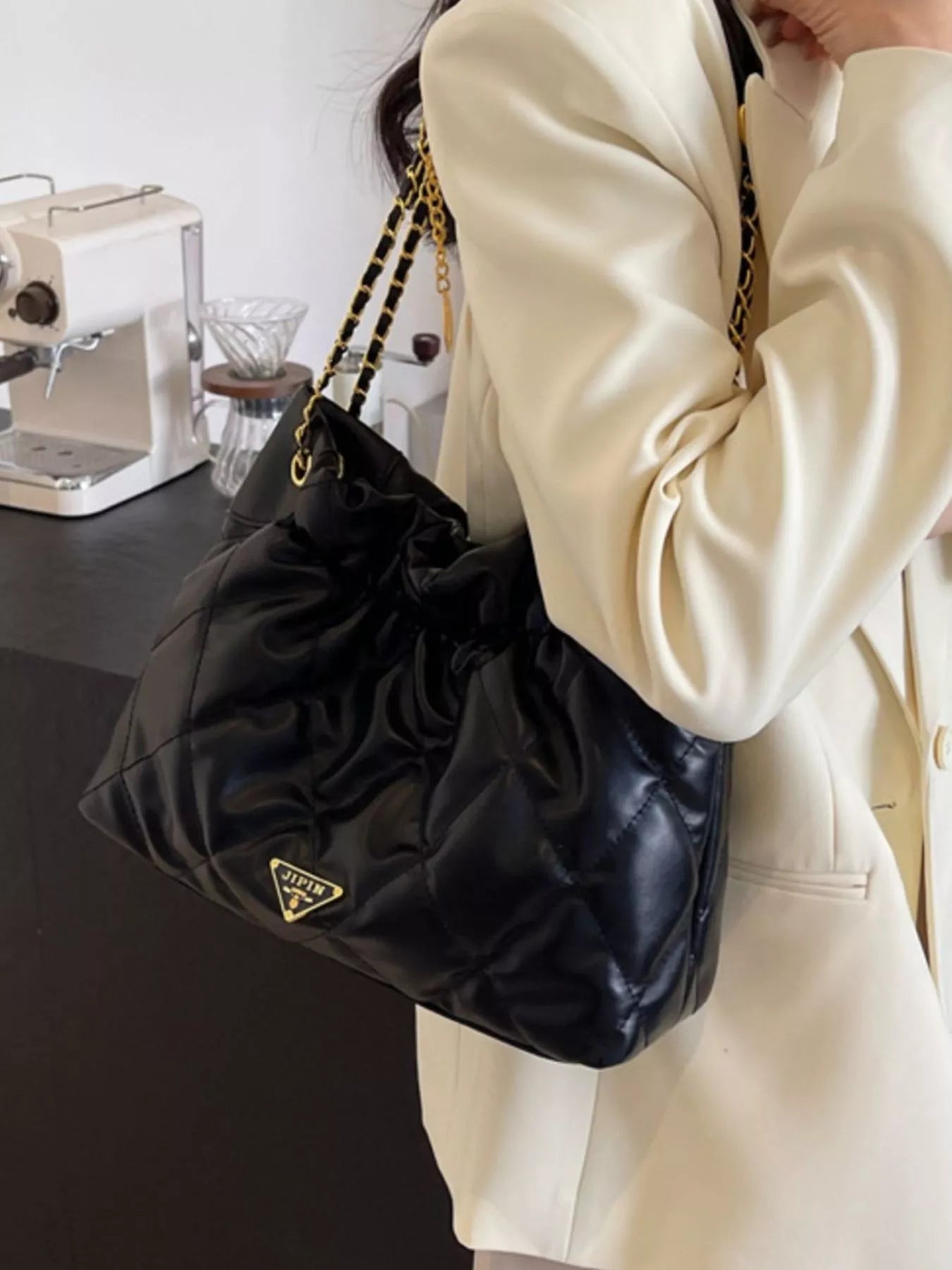 Summer Ruched Leather Shoulder Bag showcased in black leather, held elegantly with a stylish outfit.