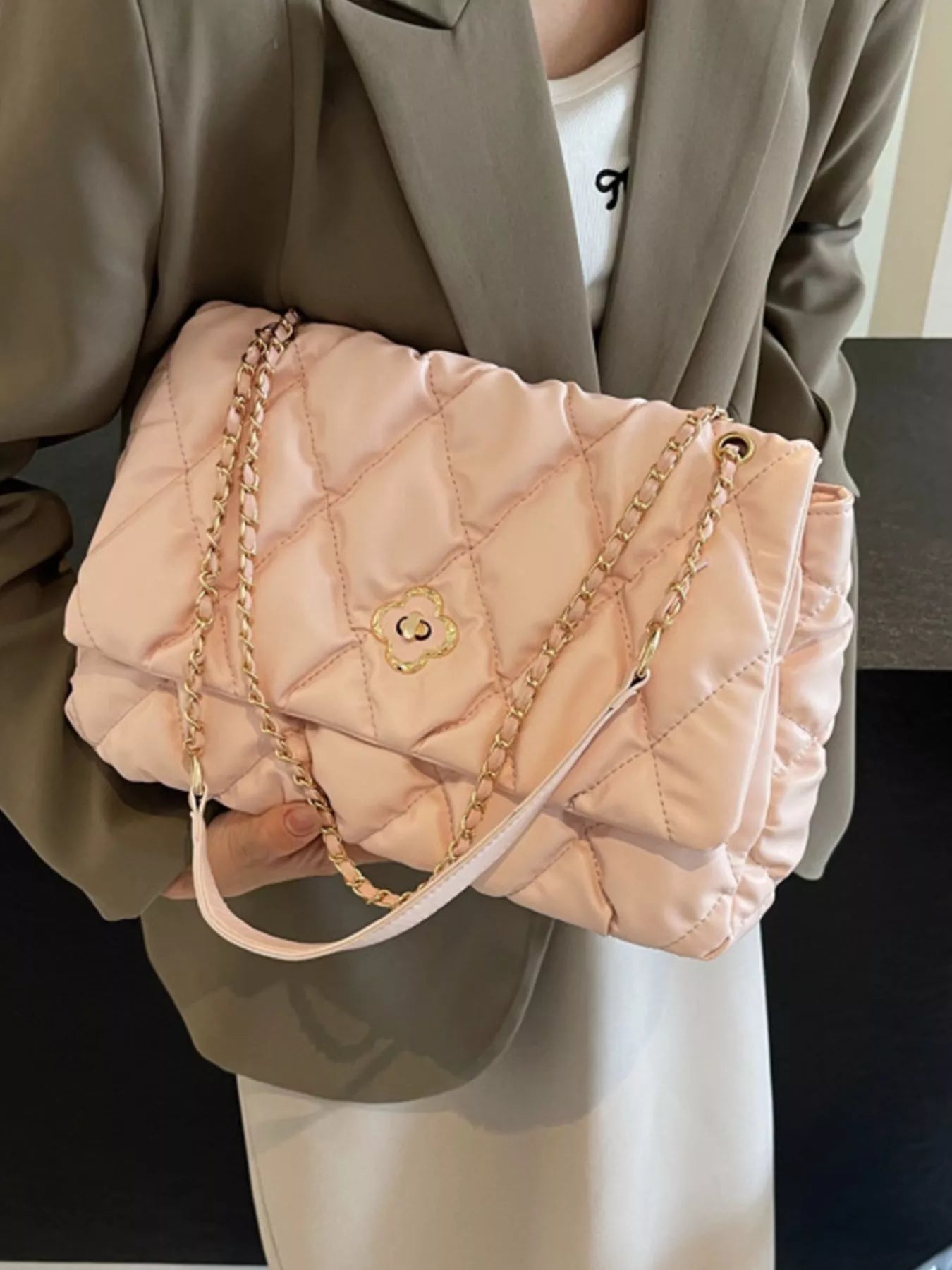 The Chicest Quilted Chain Shoulder Bag in light pink, featuring a quilted design and gold chain straps.