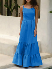 Model wearing a Tiered Maxi Cami Dress with Ruffled Hem in blue, showcasing its backless design and tiered ruffled hem.